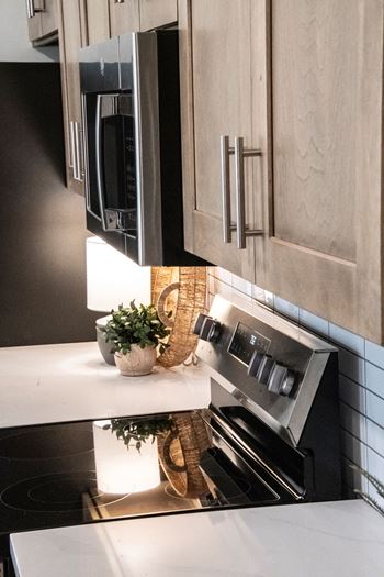 A modern kitchen with a stove top oven and a microwave above it.